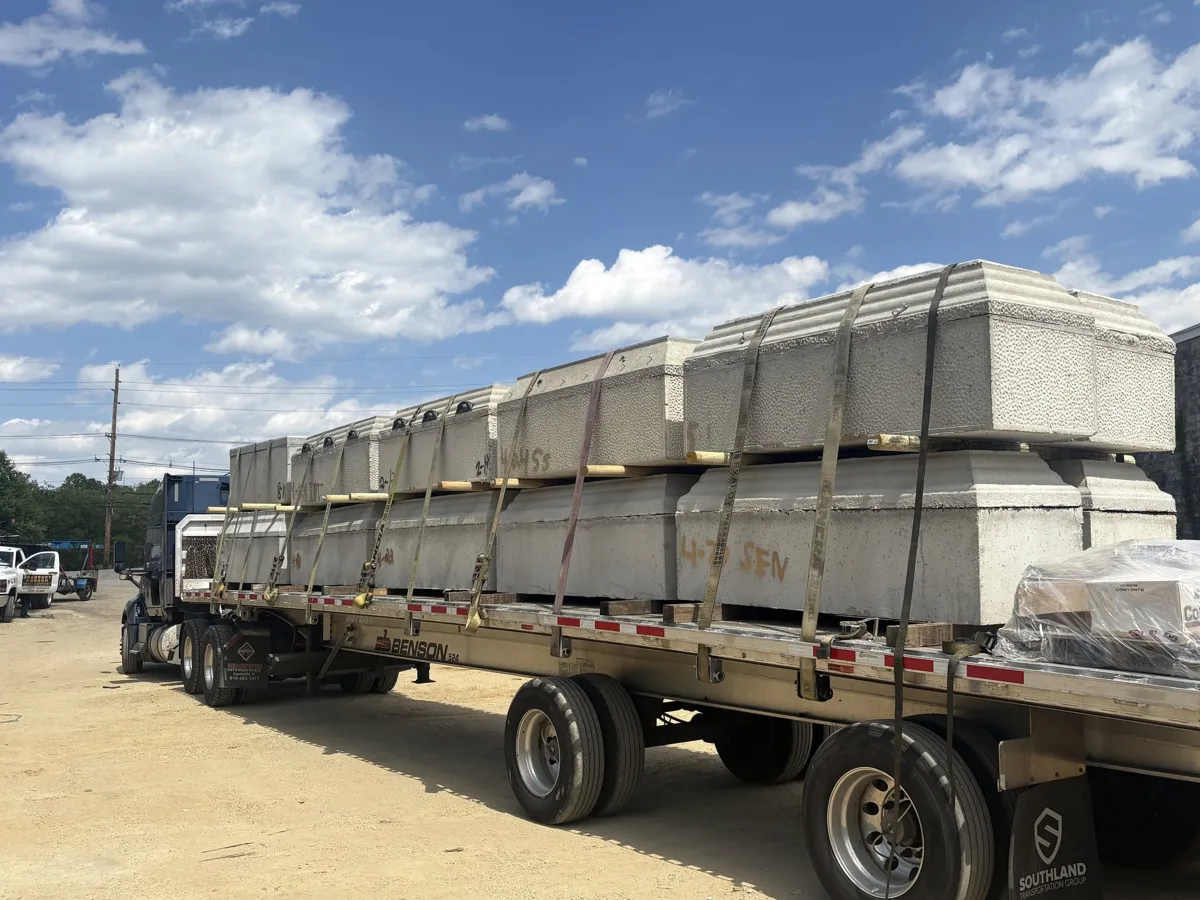 Flatbed trailer stacked with concrete burial vaults bound for North Carolina
