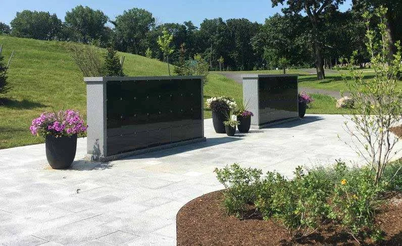 32 niche columbaria on a stone patio with planters